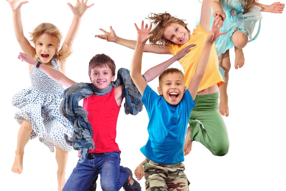 F&uuml;nf fr&ouml;hliche Kinder springen und lachen vor einem wei&szlig;en Hintergrund, in bunten Kleidern und T-Shirts.