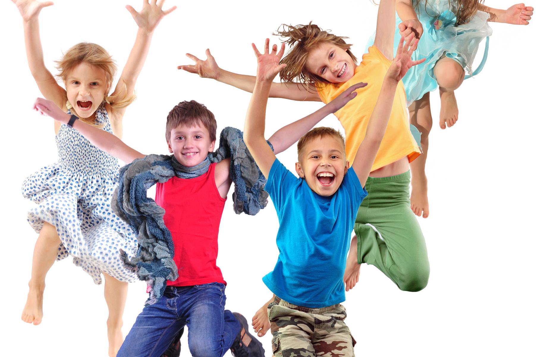 F&uuml;nf fr&ouml;hliche Kinder springen und lachen vor einem wei&szlig;en Hintergrund, in bunten Kleidern und T-Shirts.