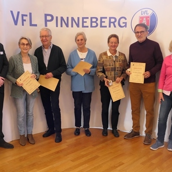 Gruppenfoto von Personen mit Urkunden vor einem Hintergrund des VfL Pinneberg Logos.