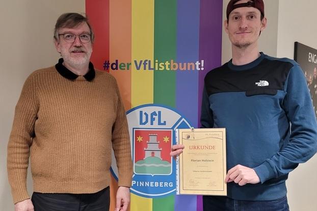 Florian Holstein erhält die silberne Verdienstnadel von Carsten Lienau.