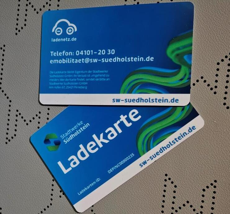 Zwei blaue Ladekarten mit der Aufschrift „Ladekarte“ auf einem strukturierten Hintergrund.