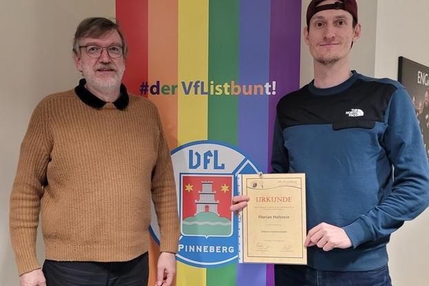 Florian Holstein erhält die silberne Verdienstnadel von Carsten Lienau.