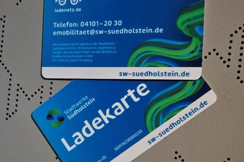 Zwei blaue Ladekarten mit der Aufschrift &bdquo;Ladekarte&ldquo; auf einem strukturierten Hintergrund.
