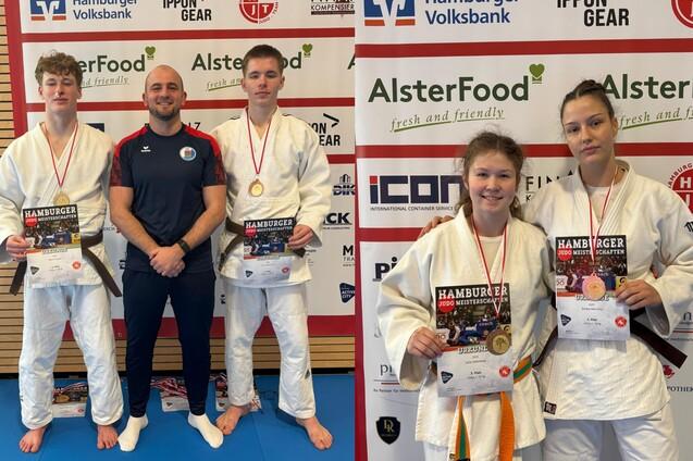 Zwei Gruppen von Judokas mit Medaillen und Urkunden stehen vor einem Hintergrund mit Sponsorenlogos.