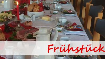 Tisch gedeckt mit vielfältigen Frühstücksleckereien, Kerzenlicht und dekorativen Elementen in einem einladenden Raum.