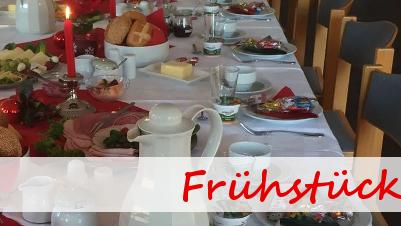 Tisch gedeckt mit vielfältigen Frühstücksleckereien, Kerzenlicht und dekorativen Elementen in einem einladenden Raum.